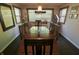 Dining room featuring a long wooden table with seating, a decorative light fixture, and window with blinds at 3942 Senour Rd, Indianapolis, IN 46239