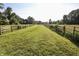 A long driveway between wooden fences leads down the property, with green grass on either side at 3942 Senour Rd, Indianapolis, IN 46239