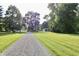 Gravel driveway leading into a grassy property with trees, other structures, and an RV at 3942 Senour Rd, Indianapolis, IN 46239