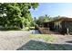 Charming home exterior with a large tree, gravel driveway and wooden deck at 3942 Senour Rd, Indianapolis, IN 46239