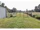 A fenced-in yard area, with a red gate and wooden fence on either side, showing grassy land at 3942 Senour Rd, Indianapolis, IN 46239