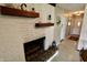 Cozy living room featuring a painted brick fireplace with wood mantel and hearth with decorative accents at 3942 Senour Rd, Indianapolis, IN 46239