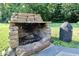 Stone fireplace and stone surround on a back patio with grill on a stone tile patio at 3942 Senour Rd, Indianapolis, IN 46239