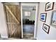 Hallway featuring rustic barn door, wood floors, and hallway with framed photos on the wall at 3942 Senour Rd, Indianapolis, IN 46239