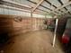 Inside a horse stall, featuring wooden walls, open space, and rustic charm, with storage and accommodations at 3942 Senour Rd, Indianapolis, IN 46239