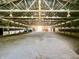 A well lit indoor arena with sandy floor and metal support beams throughout the ceiling. Tractor and attachments included at 3942 Senour Rd, Indianapolis, IN 46239