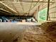 View of a well-lit, spacious indoor arena with tractor and equipment, ideal for equestrian activities at 3942 Senour Rd, Indianapolis, IN 46239