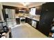 Charming kitchen featuring dark cabinetry and stainless steel appliances, complemented by white countertops at 3942 Senour Rd, Indianapolis, IN 46239