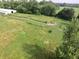 Aerial view of a spacious pasture with horses grazing, surrounded by green fields and mature trees at 3942 Senour Rd, Indianapolis, IN 46239