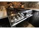 Modern stainless steel gas range with digital display and stone backsplash at 3942 Senour Rd, Indianapolis, IN 46239