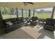Bright sun room featuring a plush black sofa, comfortable chairs, and expansive windows with scenic outdoor views at 3942 Senour Rd, Indianapolis, IN 46239