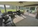 Sun room features a plush black sofa, comfortable chairs, a fireplace, and a view of the outdoor patio at 3942 Senour Rd, Indianapolis, IN 46239