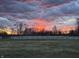 Scenic sunset view over a fenced-in yard with trees, offering tranquility and picturesque scenery at 3942 Senour Rd, Indianapolis, IN 46239