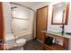 Bathroom featuring a shower-tub combo, toilet, and sink with a wooden vanity at 3948 S Woodfield Dr, New Palestine, IN 46163
