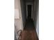 Narrow hallway with damaged flooring, pale blue walls and white trim at 4235 Foxglove Trce, Indianapolis, IN 46237