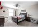 Stylish bedroom boasts a dark wood bed, ceiling fan, plush carpet, and comfortable chair at 4415 Summer Dr, Zionsville, IN 46077