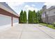 Long driveway with basketball hoop, leading to a two-car garage and landscaped yard at 4415 Summer Dr, Zionsville, IN 46077