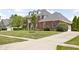 Well-manicured lawn with a large two-story brick home and concrete sidewalk at 4415 Summer Dr, Zionsville, IN 46077