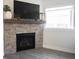 Close up view of the stone fireplace with mantle and gray wood-look floors at 485 Washington St, Fortville, IN 46040