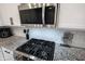 Close-up of kitchen featuring stainless steel gas range, microwave, white subway tile backsplash and granite counters at 485 Washington St, Fortville, IN 46040