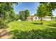 Sprawling backyard with lush lawn, mature trees, a storage shed, and a charming home exterior at 494 W Greencastle Rd, Mooresville, IN 46158