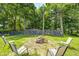 A cozy backyard firepit area is surrounded by chairs and a stone wall for outdoor gatherings at 494 W Greencastle Rd, Mooresville, IN 46158