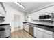 Well-lit kitchen with modern white cabinets, stainless steel appliances, and wooden flooring at 494 W Greencastle Rd, Mooresville, IN 46158
