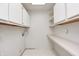 Bright laundry room features ample storage with white cabinets and shelves with white tile floors at 494 W Greencastle Rd, Mooresville, IN 46158