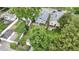Aerial view showcases home's position in a neighborhood with mature trees, lush green grass, and garage at 5209 E North St, Indianapolis, IN 46219