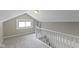 Finished attic with carpet, light-colored paint, a window and white banister at 5209 E North St, Indianapolis, IN 46219