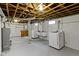 Spacious basement laundry area, featuring white washer and dryer, painted walls, and cement floors at 5209 E North St, Indianapolis, IN 46219