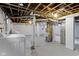 Unfinished basement with laundry, painted walls, cement floors, and exposed duct work with brick support at 5209 E North St, Indianapolis, IN 46219