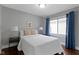 Serene bedroom with neutral décor, window with curtains, and side tables with lamps at 5209 E North St, Indianapolis, IN 46219
