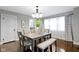 Dining room with table and bench, featuring hardwood floors, modern lighting, and neutral decor at 5209 E North St, Indianapolis, IN 46219