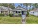 Charming bungalow with a well-maintained front yard, shrubbery, and inviting blue front door at 5209 E North St, Indianapolis, IN 46219