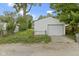White detached garage with green chain-link fence, concrete driveway, and grass visible nearby at 5209 E North St, Indianapolis, IN 46219