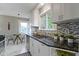 Bright kitchen featuring granite countertops, mosaic backsplash, and stainless steel dishwasher at 5209 E North St, Indianapolis, IN 46219