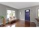 Bright and welcoming living room featuring hardwood floors, large windows, and an inviting blue front door at 5209 E North St, Indianapolis, IN 46219