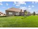 Expansive backyard showcasing the home's brick exterior and well-maintained lawn, perfect for outdoor activities at 5220 Orahood Ct, Plainfield, IN 46168