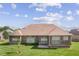 Wide backyard view of the brick home with large, well-spaced windows. Lawn is bright and green at 5220 Orahood Ct, Plainfield, IN 46168