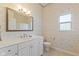 Charming bathroom with floral wallpaper, window, toilet, and vanity with a marble countertop and sink at 5220 Orahood Ct, Plainfield, IN 46168