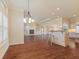 Expansive open-concept living space featuring hardwood floors, a fireplace, and a kitchen island with bar seating at 5220 Orahood Ct, Plainfield, IN 46168