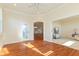 Open living room featuring hardwood floors, a white door to the backyard, and views of the living spaces at 5220 Orahood Ct, Plainfield, IN 46168