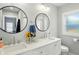 Bathroom featuring a double vanity with round mirrors and natural light from the window at 5312 Norwaldo Ave, Indianapolis, IN 46220