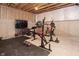 Unfinished basement space featuring installed tv and a weight lifting machine, ready for personalization at 5351 Rose Dr, Zionsville, IN 46077