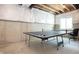 An unfinished basement features concrete walls and a ping pong table with a window at 5351 Rose Dr, Zionsville, IN 46077