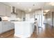 Modern kitchen features gray cabinets, stainless appliances, a large island with seating, and hardwood flooring at 5351 Rose Dr, Zionsville, IN 46077