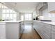 Modern kitchen features gray cabinets, stainless appliances, white subway tile, and hardwood flooring at 5351 Rose Dr, Zionsville, IN 46077