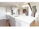 Bright kitchen features gray cabinets, stainless appliances, a large island, and hardwood flooring at 5351 Rose Dr, Zionsville, IN 46077