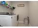 Well-organized laundry room with modern washer and dryer, complemented by overhead shelving at 5351 Rose Dr, Zionsville, IN 46077